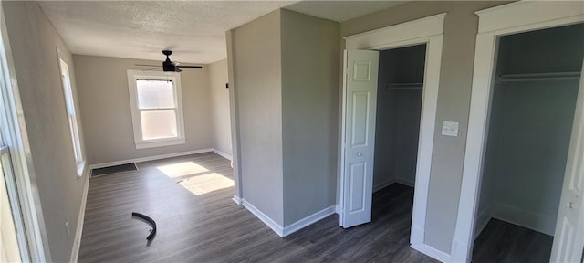 5107 E 26th St, Kansas City, MO 64127 - unfurnished bedroom featuring dark wood-type flooring, a textured ceiling, and a closet