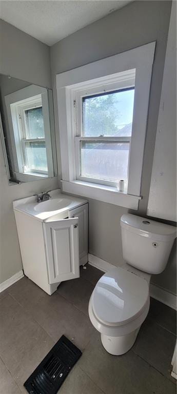 5107 E 26th St, Kansas City, MO 64127 - half bath with vanity, tile patterned flooring, and a textured ceiling