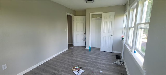 5107 E 26th St, Kansas City, MO 64127 - unfurnished bedroom with wood finished floors and a closet