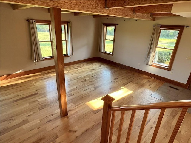 11320 Reno Rd, Oskaloosa, KS 66066 - unfurnished room with light wood-style floors and beamed ceiling