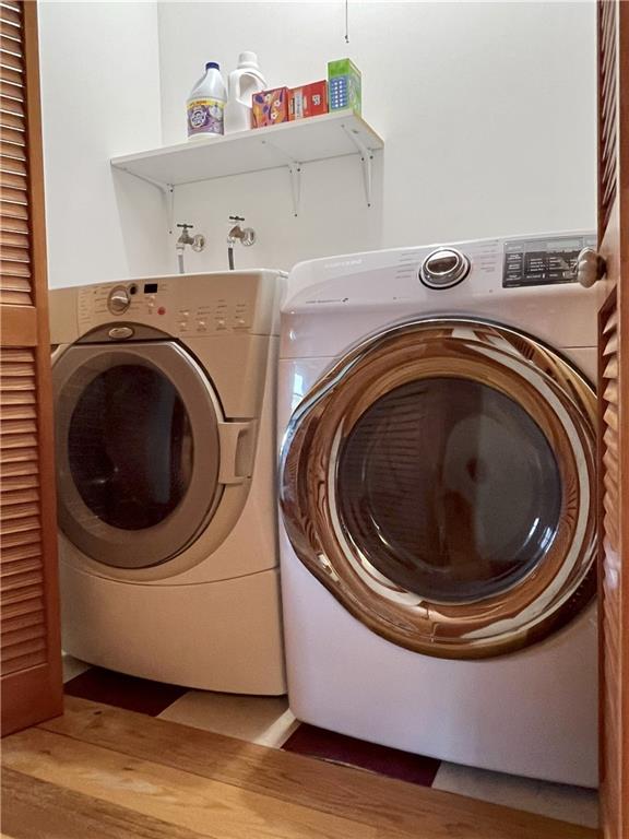 11320 Reno Rd, Oskaloosa, KS 66066 - washroom featuring washer and clothes dryer and wood finished floors