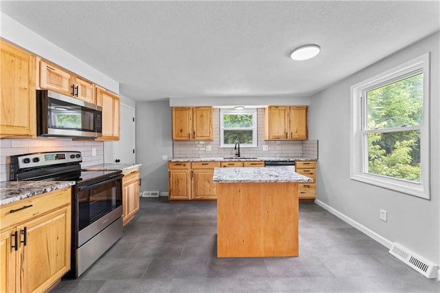 26 Misty Springs Cir, Platte City, MO 64079 - kitchen featuring stainless steel appliances, backsplash, a center island, and light stone countertops
