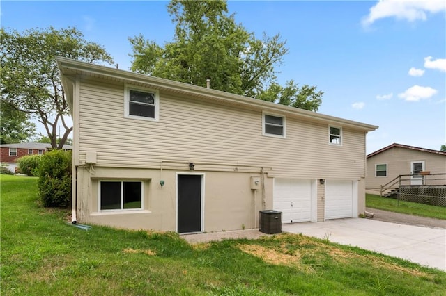 26 Misty Springs Cir, Platte City, MO 64079 - rear view of house with concrete driveway, a garage, a lawn, and stucco siding