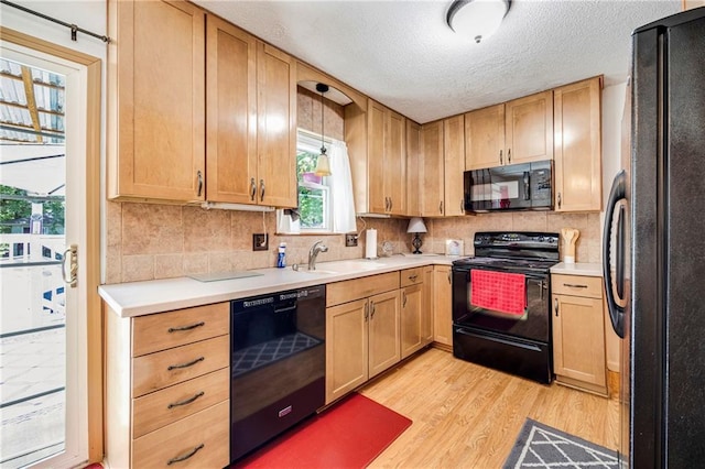 300 NE R D Mize Rd, Blue Springs, MO 64014 - kitchen featuring black appliances, light wood-style floors, decorative backsplash, light countertops, and a textured ceiling