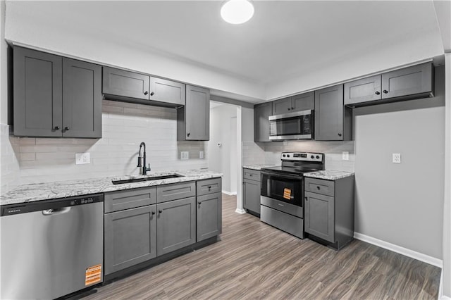 10240 W 96th Ter Unit B, Overland Park, KS 66212 - kitchen featuring appliances with stainless steel finishes, decorative backsplash, wood finished floors, and light stone countertops