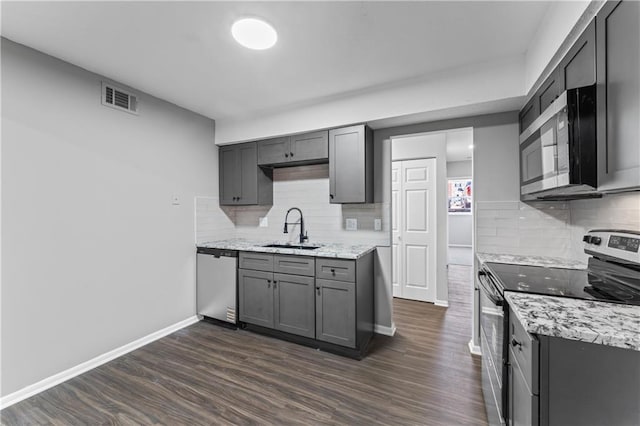 10240 W 96th Ter Unit B, Overland Park, KS 66212 - kitchen with appliances with stainless steel finishes, gray cabinets, dark wood-type flooring, decorative backsplash, and light stone counters