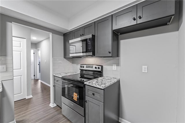 10240 W 96th Ter Unit B, Overland Park, KS 66212 - kitchen with appliances with stainless steel finishes, backsplash, gray cabinetry, and wood finished floors