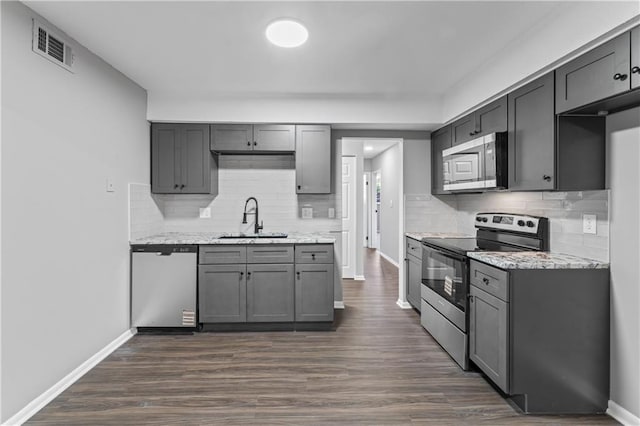 10240 W 96th Ter Unit B, Overland Park, KS 66212 - kitchen featuring stainless steel appliances, decorative backsplash, dark wood finished floors, and gray cabinetry