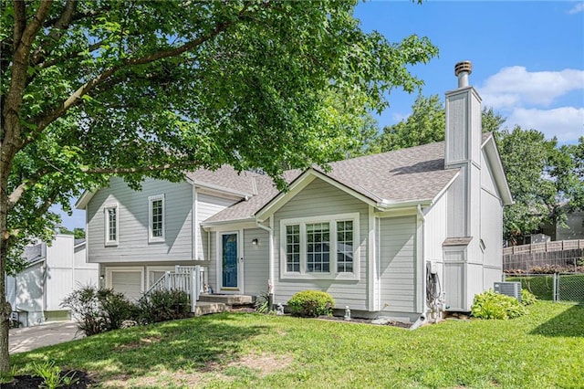 10512 Shelton Ave, Edwardsville, KS 66111 - split level home featuring roof with shingles, an attached garage, and a chimney