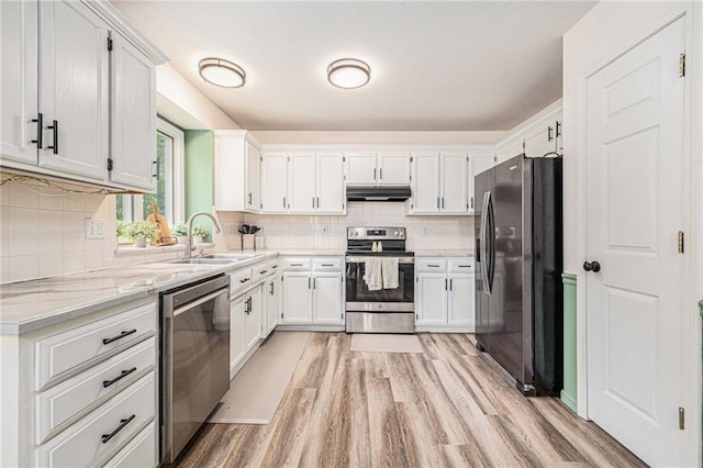 10512 Shelton Ave, Edwardsville, KS 66111 - kitchen featuring appliances with stainless steel finishes, under cabinet range hood, light wood-type flooring, backsplash, and white cabinets