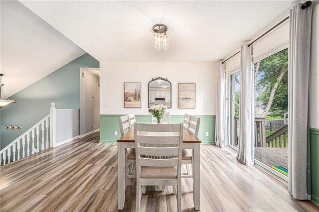 10512 Shelton Ave, Edwardsville, KS 66111 - dining space featuring wood finished floors, a textured ceiling, lofted ceiling, and a chandelier