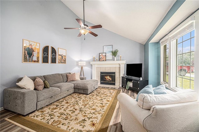 10512 Shelton Ave, Edwardsville, KS 66111 - living area with wood finished floors, a tiled fireplace, ceiling fan, and high vaulted ceiling