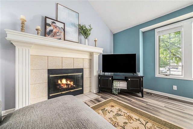 10512 Shelton Ave, Edwardsville, KS 66111 - living area featuring a fireplace, wood finished floors, and vaulted ceiling