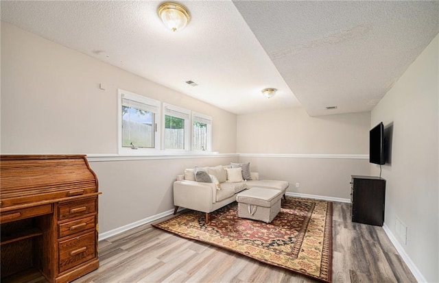 10512 Shelton Ave, Edwardsville, KS 66111 - living area featuring wood finished floors and a textured ceiling