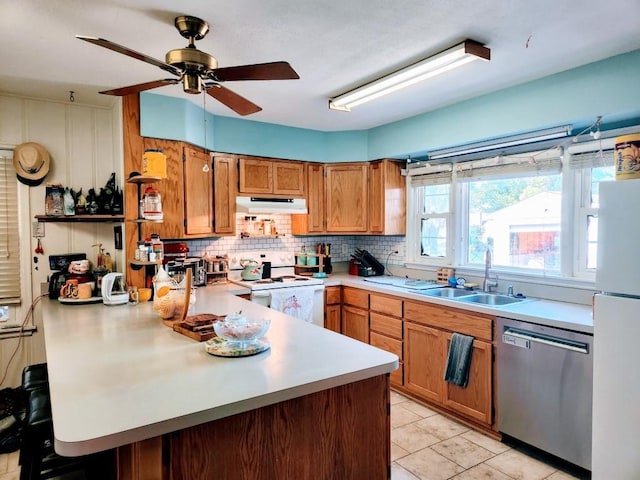 520 S Russell St, Odessa, MO 64076 - kitchen with white appliances, under cabinet range hood, light countertops, a peninsula, and brown cabinetry