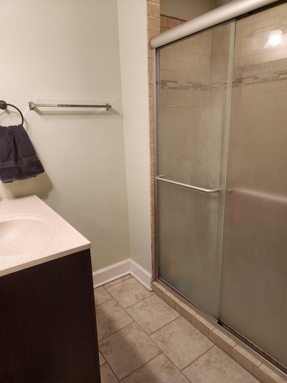 520 S Russell St, Odessa, MO 64076 - bathroom featuring a shower stall, vanity, and tile patterned floors