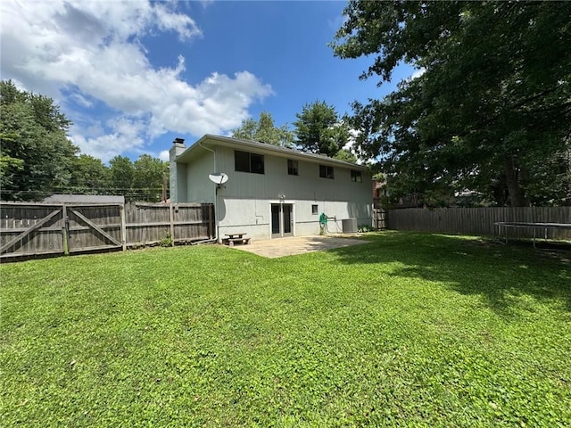 1012 NW A St, Blue Springs, MO 64015 - rear view of house with a trampoline, a chimney, a patio area, and a fenced backyard