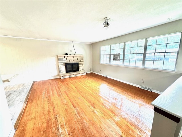 1012 NW A St, Blue Springs, MO 64015 - unfurnished living room featuring wood finished floors and a stone fireplace
