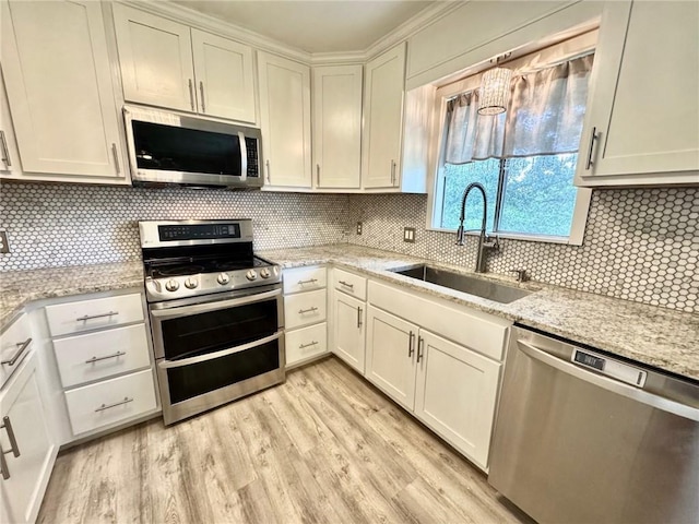 1012 NW A St, Blue Springs, MO 64015 - kitchen with stainless steel appliances, light wood-style flooring, decorative backsplash, light stone counters, and white cabinetry