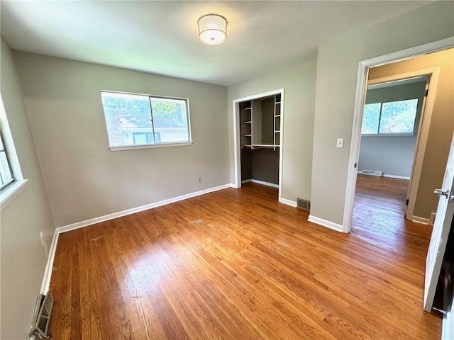1012 NW A St, Blue Springs, MO 64015 - unfurnished bedroom featuring multiple windows, light wood-type flooring, and a closet