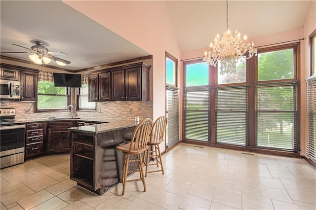 8300 W 148th St, Overland Park, KS 66223 - kitchen with appliances with stainless steel finishes, tasteful backsplash, dark brown cabinetry, a chandelier, and vaulted ceiling