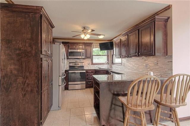 8300 W 148th St, Overland Park, KS 66223 - kitchen featuring stainless steel appliances, a peninsula, decorative backsplash, ceiling fan, and dark brown cabinets