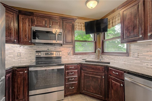 8300 W 148th St, Overland Park, KS 66223 - kitchen with appliances with stainless steel finishes, dark stone counters, decorative backsplash, light tile patterned flooring, and dark brown cabinets