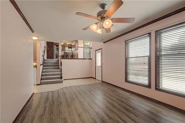 8300 W 148th St, Overland Park, KS 66223 - unfurnished living room featuring wood finished floors, stairway, ceiling fan, and ornamental molding