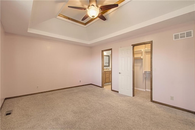 8300 W 148th St, Overland Park, KS 66223 - unfurnished bedroom featuring a tray ceiling, carpet, a spacious closet, a closet, and ensuite bathroom