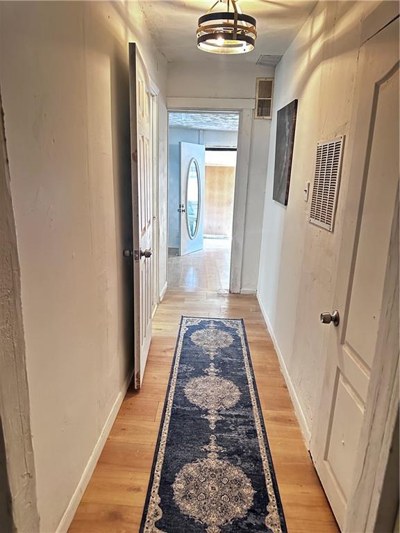 300 W Sea Ave, Independence, MO 64050 - corridor with light wood-style flooring and a chandelier