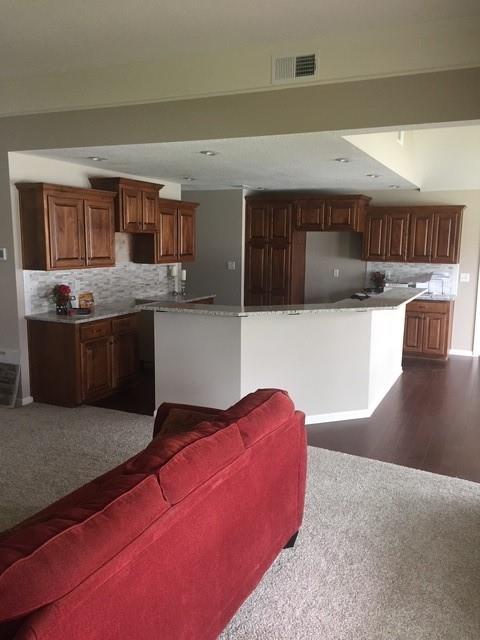 19706 E 20th St N, Independence, MO 64058 - kitchen featuring dark carpet, backsplash, a center island, and freestanding refrigerator