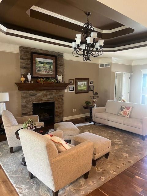 19706 E 20th St N, Independence, MO 64058 - living room with crown molding, a tray ceiling, wood finished floors, a chandelier, and a fireplace