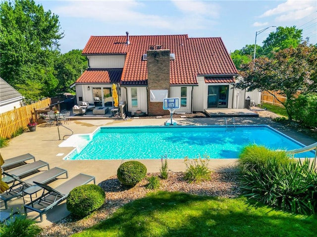 5490 W 85th Ter, Prairie Village, KS 66207 - back of property featuring a tile roof, a fenced backyard, a patio area, and a chimney