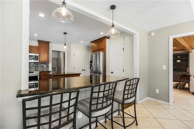 5490 W 85th Ter, Prairie Village, KS 66207 - kitchen with stainless steel appliances, backsplash, a breakfast bar, light tile patterned floors, and pendant lighting