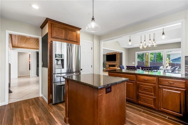5490 W 85th Ter, Prairie Village, KS 66207 - kitchen with stainless steel fridge with ice dispenser, a center island, dark wood-style flooring, hanging light fixtures, and dark stone countertops
