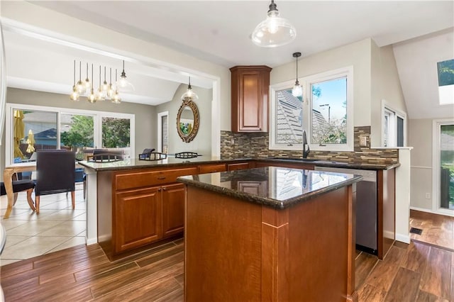5490 W 85th Ter, Prairie Village, KS 66207 - kitchen with a kitchen island, stainless steel dishwasher, tasteful backsplash, dark stone counters, and wood finished floors