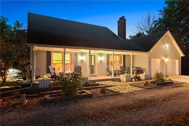1684 Quarry Rd, Bates City, MO 64011 - view of front facade with a porch, driveway, a chimney, and a garage