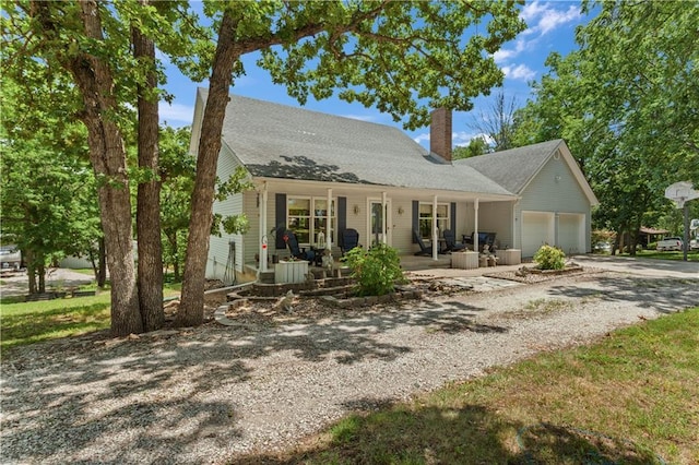 1684 Quarry Rd, Bates City, MO 64011 - view of front of home featuring driveway, a chimney, covered porch, and an attached garage