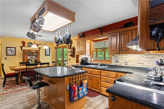 1684 Quarry Rd, Bates City, MO 64011 - kitchen featuring dark countertops, a kitchen island, brown cabinets, a breakfast bar, and backsplash