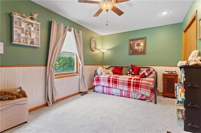 1684 Quarry Rd, Bates City, MO 64011 - carpeted bedroom with wainscoting, a textured ceiling, ceiling fan, and wooden walls