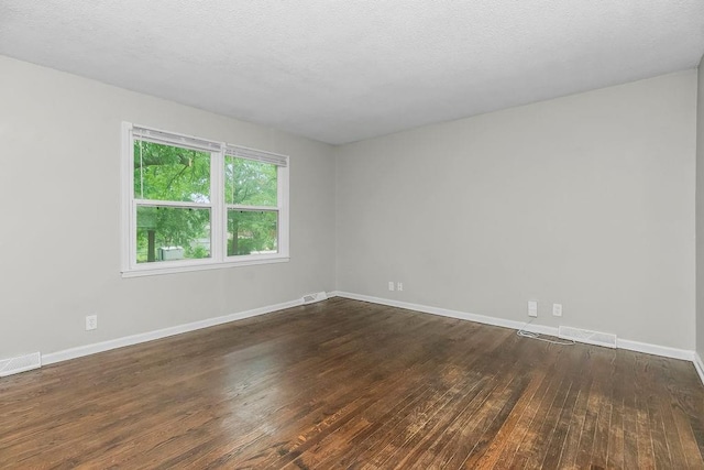 13309 Winchester Ave, Grandview, MO 64030 - spare room featuring dark wood-type flooring and baseboards