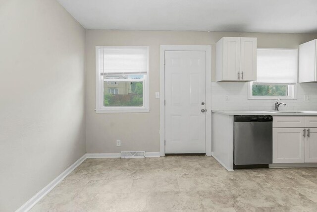 13309 Winchester Ave, Grandview, MO 64030 - kitchen featuring dishwasher, light countertops, white cabinetry, and tasteful backsplash