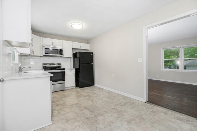 13309 Winchester Ave, Grandview, MO 64030 - kitchen with appliances with stainless steel finishes, light countertops, white cabinets, and decorative backsplash