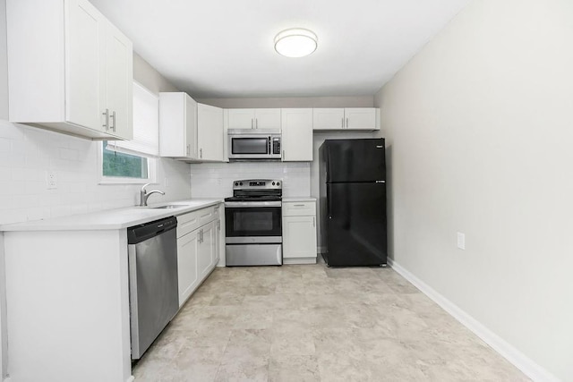 13309 Winchester Ave, Grandview, MO 64030 - kitchen featuring stainless steel appliances, tasteful backsplash, light countertops, and white cabinets