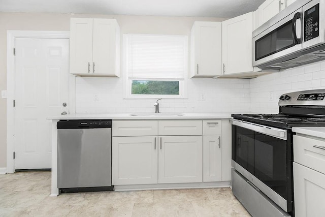 13309 Winchester Ave, Grandview, MO 64030 - kitchen with stainless steel appliances, light countertops, tasteful backsplash, and white cabinetry