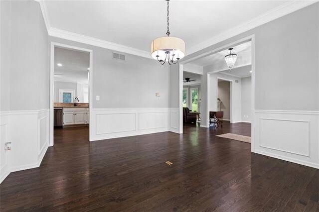 5329 Park St, Shawnee, KS 66216 - unfurnished dining area with a chandelier, crown molding, ceiling fan, a wainscoted wall, and dark wood-style floors
