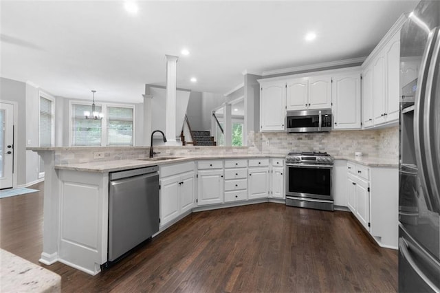 5329 Park St, Shawnee, KS 66216 - kitchen with appliances with stainless steel finishes, a peninsula, healthy amount of natural light, tasteful backsplash, and recessed lighting