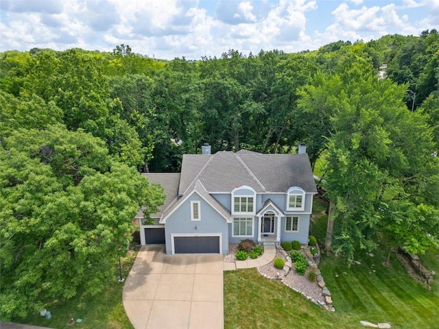 5329 Park St, Shawnee, KS 66216 - traditional home featuring driveway, a chimney, stucco siding, a shingled roof, and a garage