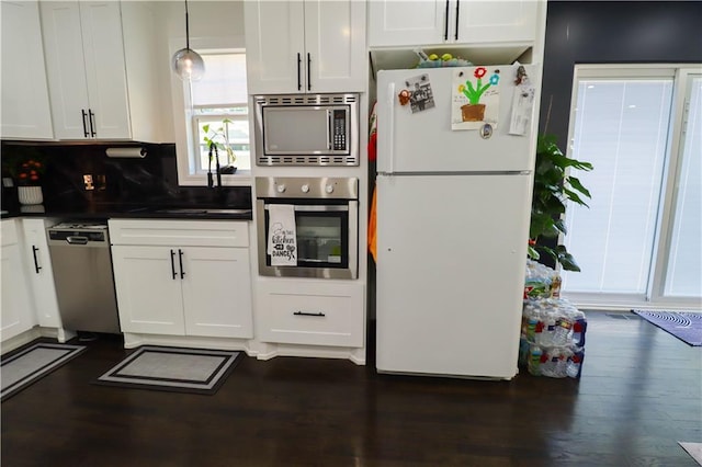 2725 N 20th St, Kansas City, KS 66104 - kitchen with stainless steel appliances, white cabinetry, dark countertops, dark wood-type flooring, and decorative backsplash