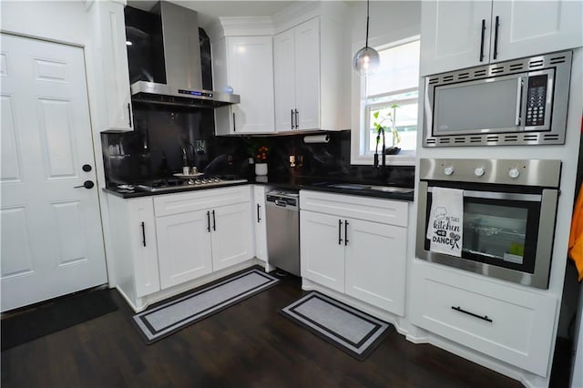 2725 N 20th St, Kansas City, KS 66104 - kitchen with stainless steel appliances, wall chimney range hood, dark countertops, dark wood finished floors, and white cabinets
